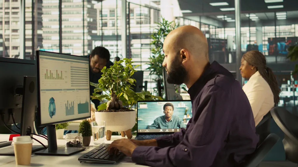 Business leader managing a remote team through a video call in a modern office